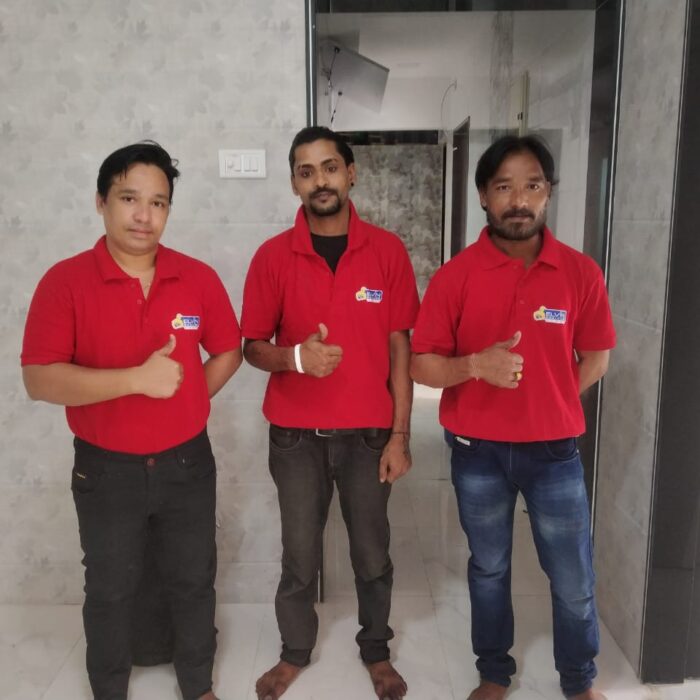 three people cleaning the house in Andheri, Mumbai, using brooms, mops, and cleaning products.