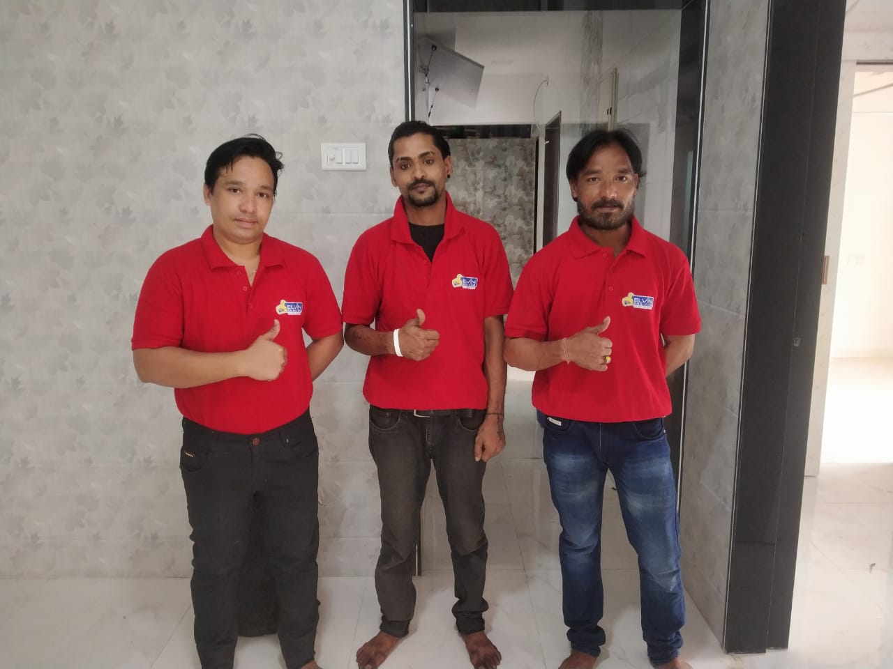 three people cleaning the house in Andheri, Mumbai, using brooms, mops, and cleaning products.